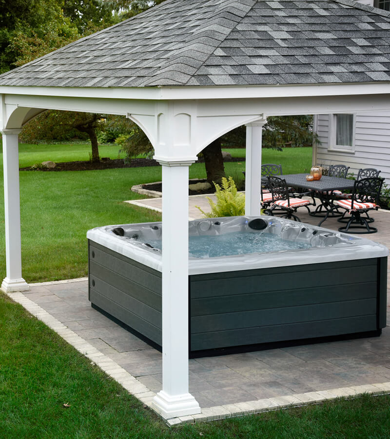 Hot tub under a pergola on a paver patio